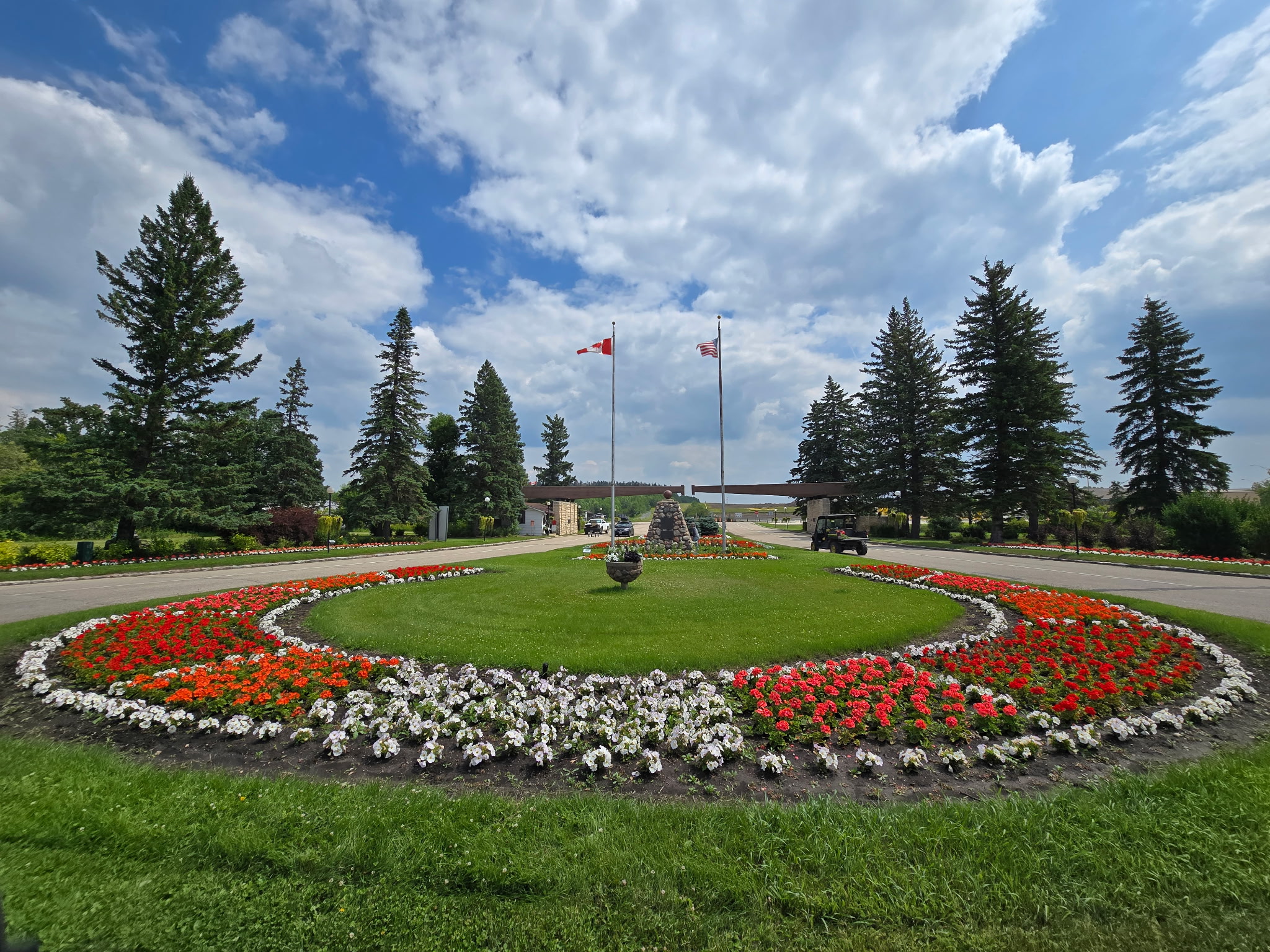Flower beds around the two flags at the park entrance.